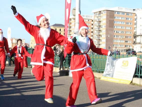 Two Santa Dash runners cross the finish line (Photograph: Andy Voakes)