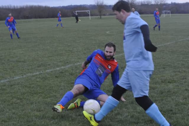 A Battle Baptists third team player slides in on an AFC Hollington opponent.