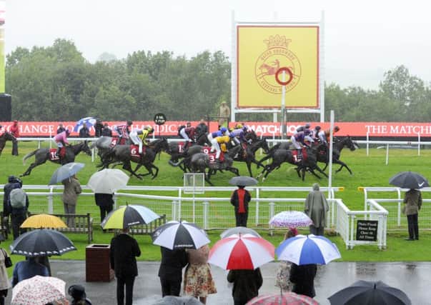 The brollies are up for a day to remember - for the wrong reasons - at Glorious Goodwood / Picture by Malcolm Wells