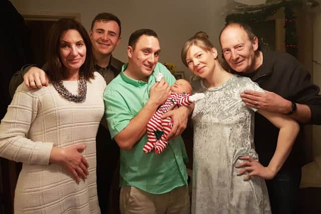 Sabrina Simonini, 29, second from right, and Kevin Flynn, 37, holding his daughter Skyla Rae Flynn, who was born on Christmas Day. Pictured with their family.