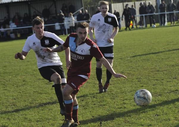 Bexhill United midfielder Curtis Beale and Little Common player Harry Saville in the thick of the action during the Boxing Day derby. Picture by Simon Newstead