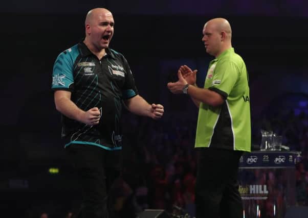 Rob Cross celebrates his momentous victory as Michael van Gerwen graciously applauds in the background. Picture courtesy Lawrence Lustig/PDC