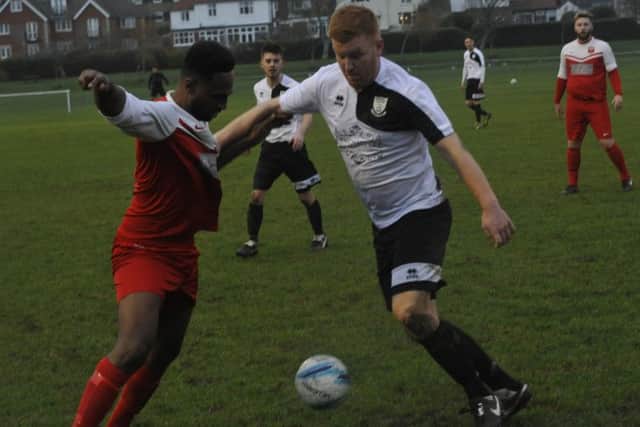 Bexhill United defender Zack McEniry tussles with Seaford forward Khalid Bilal.