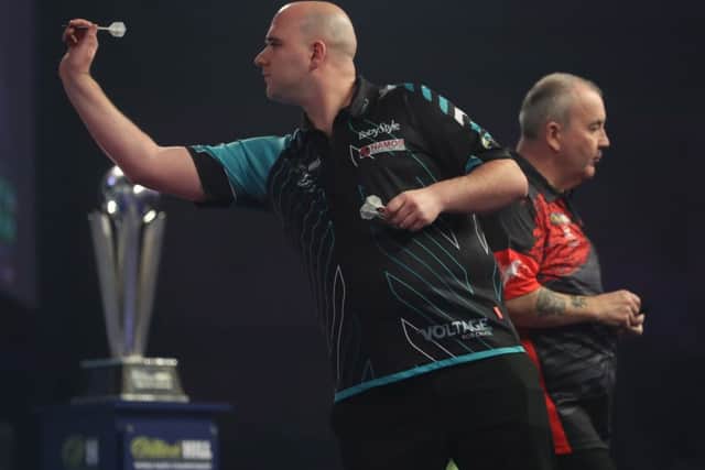 Rob Cross at the oche with Phil Taylor in the background.