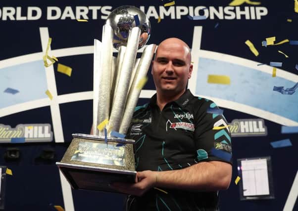 Rob Cross proudly clutches the William Hill World Darts Championship trophy. Picture courtesy Lawrence Lustig/PDC