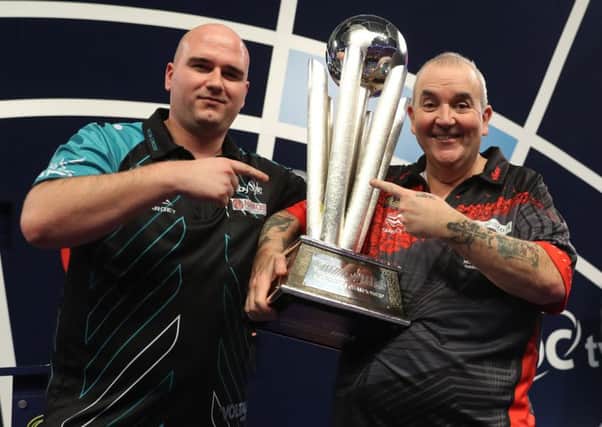 Rob Cross (left) and Phil Taylor with the William Hill World Darts Championship trophy. Picture courtesy Lawrence Lustig/PDC