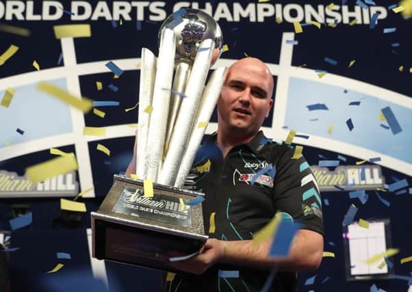 Rob Cross clutches the William Hill World Darts Championship trophy on stage at Alexandra Palace. Picture courtesy Lawrence Lustig/PDC