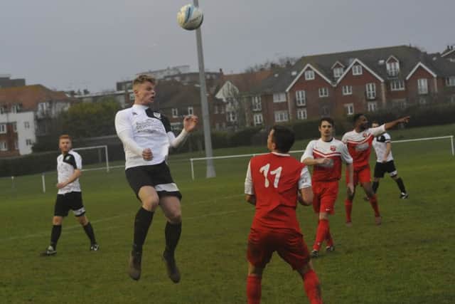 Lewis McGuigan, scorer of Bexhill United's second goal against Seaford Town, wins a header.