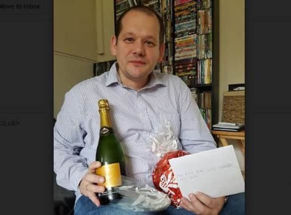 Stewart Povey-Meier with the labrador owner's 'thank you' card and a bottle of champagne