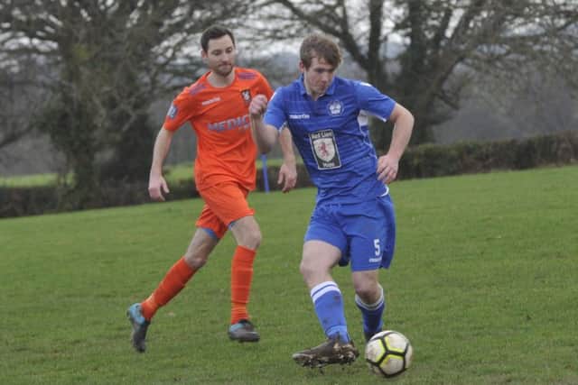 Jordan Cole on the ball for Sidley United as Battle Baptists attacking player Dean Boyd looks on.