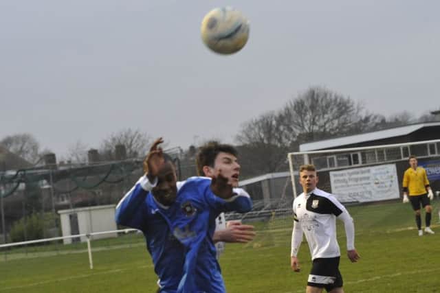 Connor Robertson, scorer of Bexhill United's equaliser, goes up for a header.