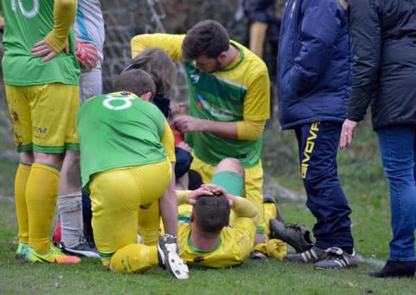 Injured Westfield captain Martyn Durrant is attended to by his team-mates. Pictures by Justin Lycett