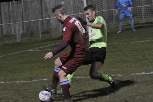 Jamie Crone, scorer of Little Common's opening goal, is on the receiving end of a tackle from Tom Shelley, for which the Ringmer defender was booked.