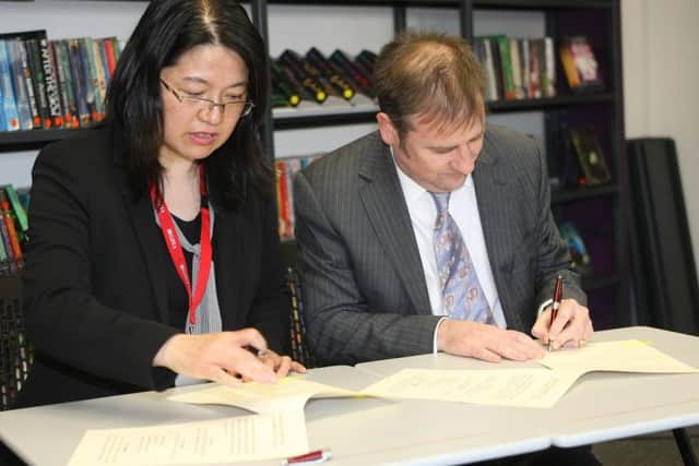 Dr Ying Zheng, UK director of the Confucius Institute, and head teacher Adam Whitehead signing the agreement