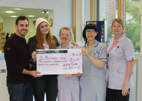 Jake Costin and Hannah Pheasant, left, present the cheque at St Barnabas House hospice