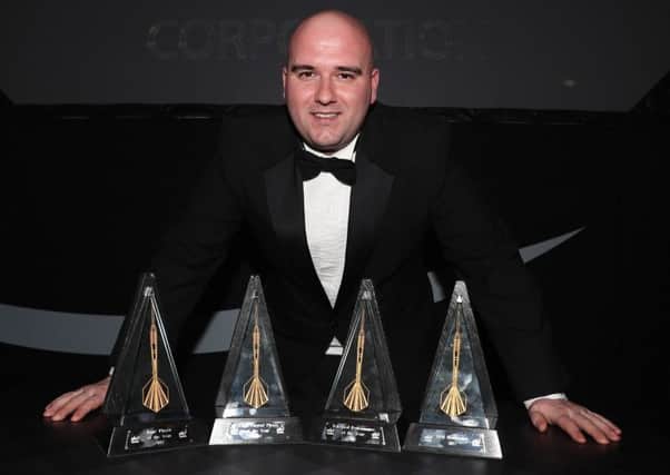 Rob Cross stands proudly alongside his four trophies at the PDC Annual Awards Dinner. Picture courtesy Lawrence Lustig/PDC
