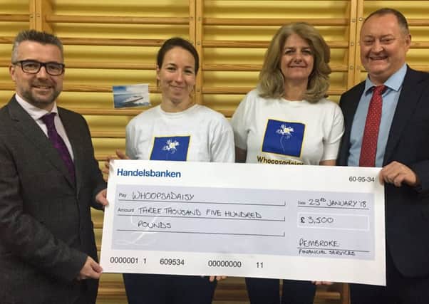 Pembroke Financial Services director Keith Bonner, left, and managing director Keith Relf present the cheque to Whoopsadaisy conductor Zsofia Varga, second left, and community fundraiser Caroline Mantle