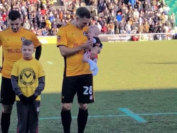 Mickey Demetriou with his son, Theo, on the pitch before Newport's FA Cup third round tie with Leeds