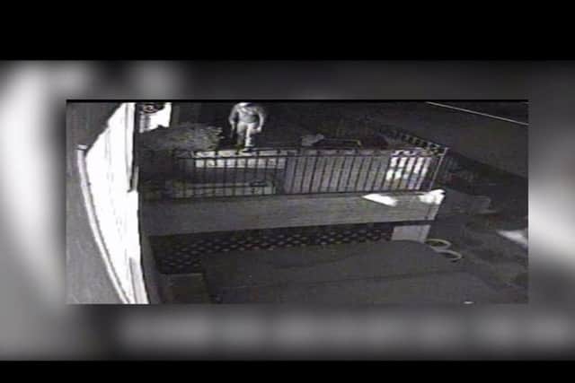 The burglar gets ready to enter a property with a sawn-off shotgun. CCTV footage released by Surrey Police