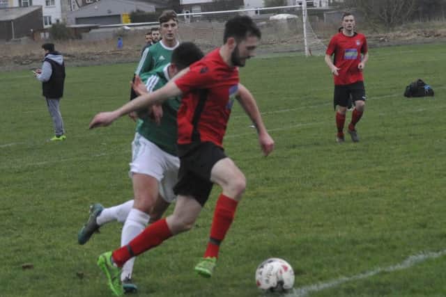 Rye Town forward Charlie Stevens tries to escape the attentions of a Bexhill Town defender.