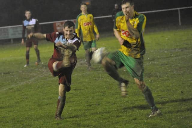 Adam Smith, scorer of Little Common's first goal against Hailsham Town, tries to hook the ball forwards.