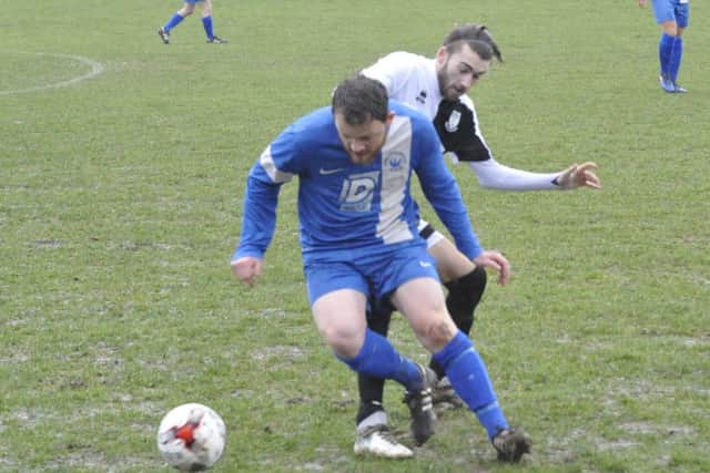 Bexhill midfielder Nathan Lopez puts in a challenge.