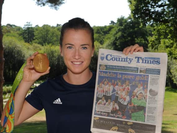 Maddie Hinch shows off her gold medal from the Rio Olympics and our sister paper the West Sussex County Times' front page. Picture by Jon Rgby