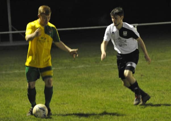 Bexhill United's Connor Robertson keeps a close eye on Hailsham Town wide player Harry Butler. Pictures by Simon Newstead