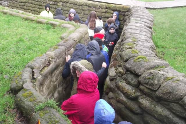 Students from The Towers walking in the muddy trenches in Ypres