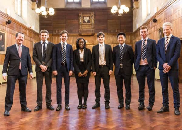 Headmaster Dominic Oliver with the seven students offered places to study at Oxford and Cambridge