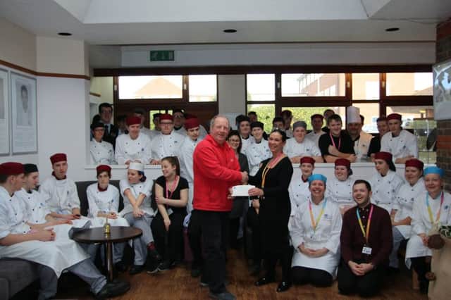 Lyanne Trenaman presents the cheque to Chris Downton, with SDC Catering & Hospitality students. SUS-180214-125916001