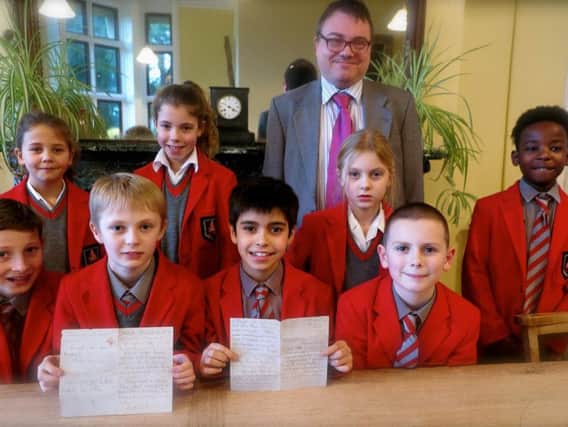 Sompting Abbotts headmaster Stuart Douch and pupils display the letter hidden under floorboards for almost 80 years