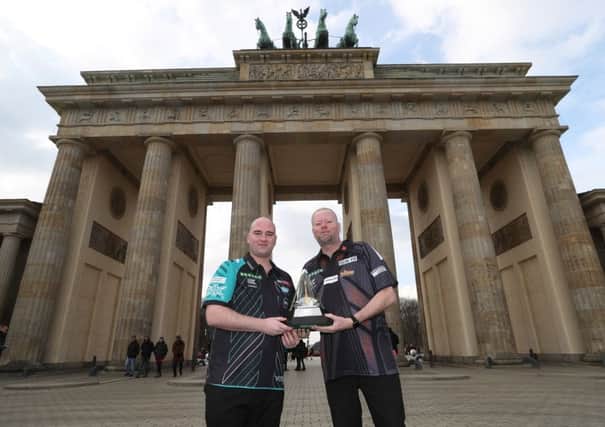 Rob Cross (left) and Raymond van Barneveld hold the Unibet Premier League trophy outside the Brandenburg Gate in Berlin. Picture courtesy Lawrence Lustig/PDC
