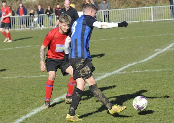 Rye Town midfielder Sammy Foulkes keeps a close eye on a Hollington United opponent. Picture by Simon Newstead
