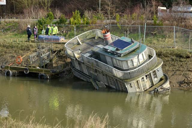 Stricken: The semi-submerged houseboat The Grey Lady on the banks of the river this week