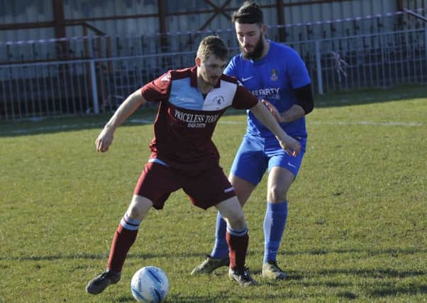 Little Common midfielder Adam Smith holds off a Selsey opponent. Pictures by Simon Newstead