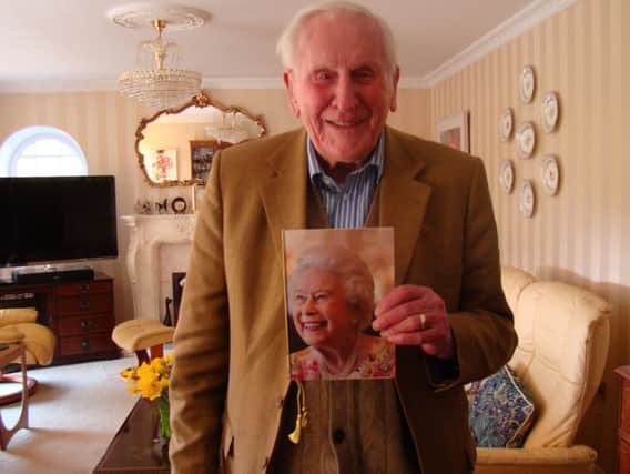 John Creaton, who turned 100 on Friday, holding his birthday card from the Queen