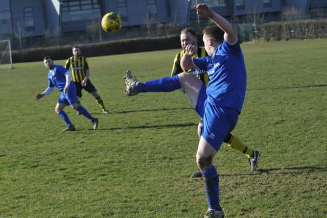 A Bexhill Rovers player helps the ball forward against Catsfield.