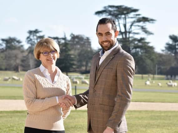 Tracey Greaves, chief commercial officer at Goodwood, and Will Windsor, managing director at South Downs Water shake hands on the partnership outside Goodwood House