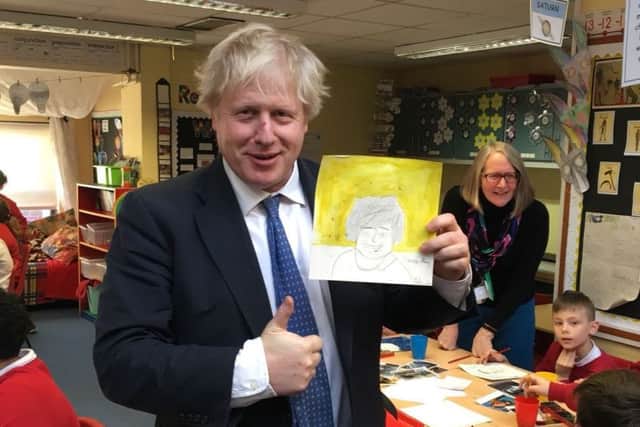 Boris with the picture of Theresa May drawn by one of the pupils SUS-180903-132658001