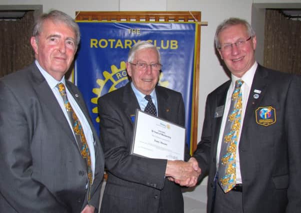 Tony Moore, centre, receives his certificate from RIBI president Dennis Spiller, right, with Rotary District Governor James Onions