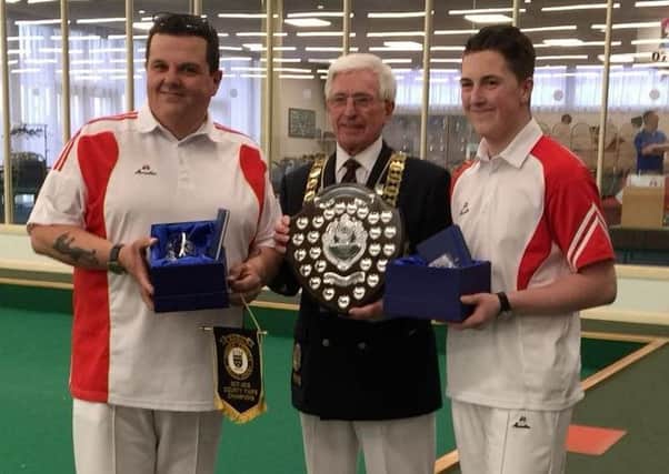 County indoor pairs champions Rob and Ajay Morphett with county president Barry Baillie.