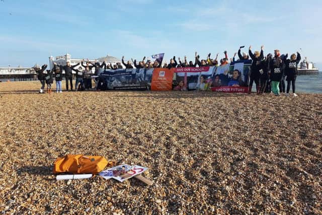 Save Our Schools campaigners on the beach with their giant banner