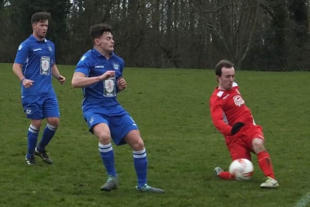 An Ore Athletic player slides to hook the ball forwards against Sidley United. Picture courtesy Paul Huggins