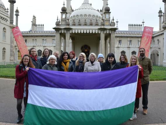 Louise Peskett and staff from The Pensions Regulator in Brighton with the suffrage flag in Brighton