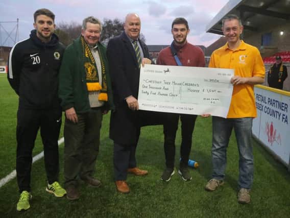 Chestnut Tree House ambassador receives a cheque from Horsham FC's commercial director Paul Osborn. Also pictured are players Steve Metcalf and Lewis Hyde and supporter Tim Harrison