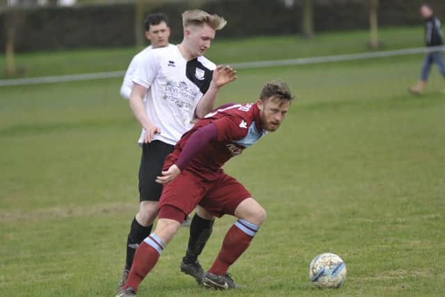 Jamie Crone, scorer of Little Common's opening goal, holds off Bexhill United midfielder Liam Foster.