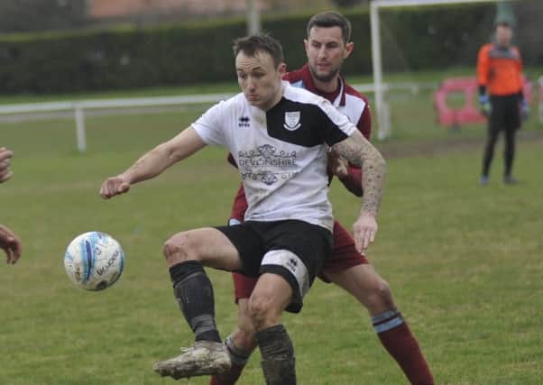 Bexhill United midfielder Gordon Cuddington holds off Little Common defender Lewis Parsons at The Polegrove on Easter Monday. Picture by Simon Newstead