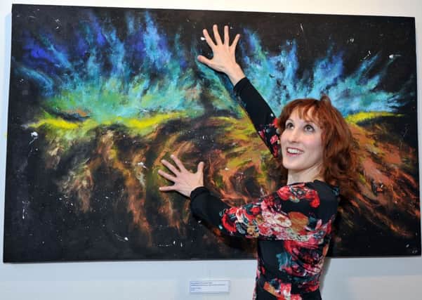 Cat McLelland with her painting A Hundred Thousand Stars from her previous exhibition Journeys, Memories, Dreams, Reflections