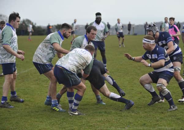 A trio of Hastings & Bexhill players combine to tackle a Lewes opponent. Pictures by Simon Newstead